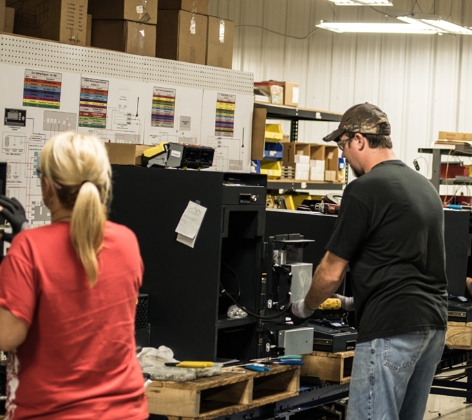 Two Cennox employees working on a fireproof safe in the Cennox factory